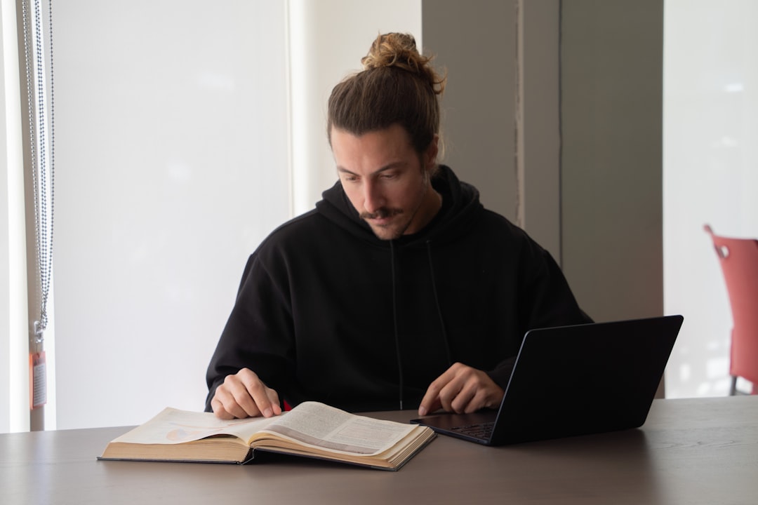 Student preparing for the Digital SAT with a laptop and book